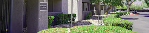 A laundry room sign is on a building in a quiet area.