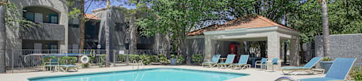 A pool with a slide and a gazebo in the background.