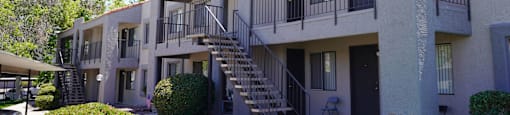 A building with a balcony and stairs leading to the second floor.