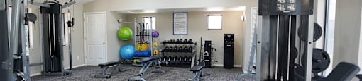A gym with a variety of equipment including a leg press machine.
