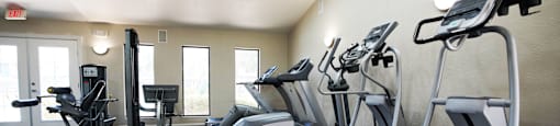 A gym with treadmills and elliptical machines.