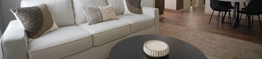 A living room with a white couch and a black coffee table.