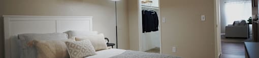 A bedroom with a large bed and a lamp.