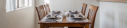 A dining room with a table set for two.