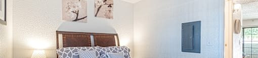 A bedroom with a bed, a nightstand, and pictures on the wall.