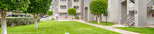 El Encanto outside view with nice lush grass area with trees around