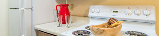 A white refrigerator is next to a white stove in a kitchen.