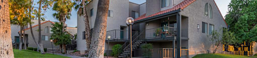 outside grass area with paved walkway in front of apartment buildings