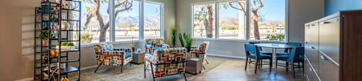 A living room with a couch, chairs, and a dining table with a view of the outdoors.