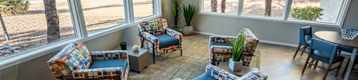 A sunny room with a couch, chair, and table.
