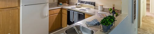 Estancia kitchen with plenty of cabinetry, a fridge, stove, and a sink