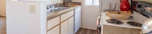 kitchen with white cabinets and appliances and window providing natural light