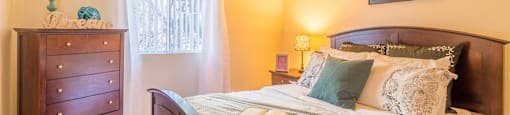 The Springs bedroom with carpet flooring and nice lighting