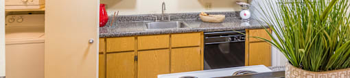 Kitchen with wood cabinets and sink next to laundry room