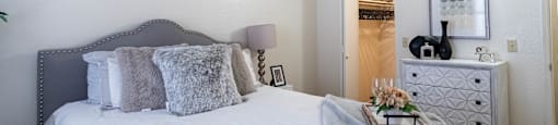 a bedroom with a large bed and a dresser with a mirror on the wall