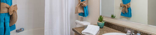 Cantera bathrooms with vanity sinks and shower tub combo