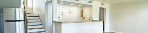 large open room with a bar top and stairs leading to the 2nd level