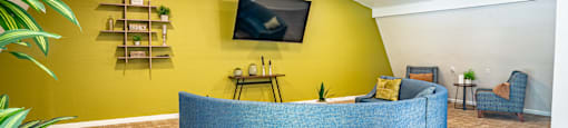 a reception area with a yellow wall and blue furniture