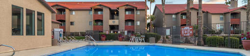 Enclave sparkling pool view with trees surrounding and lounge area