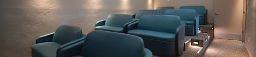 A row of blue seats in a dimly lit room.