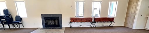 a living room with a fireplace and three windows