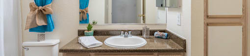 Cantera bathrooms with vanity sinks and shower tub combo