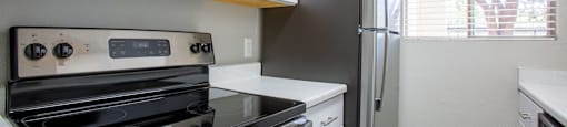 A kitchen with a black stove top oven and a black refrigerator.