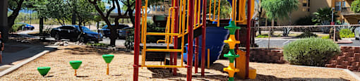 a colorful playground in a park with trees in the background
