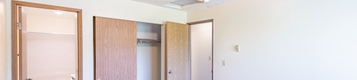 a bedroom with white walls and a carpeted floor