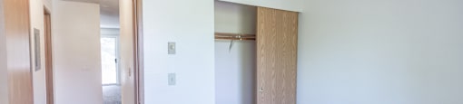 a bedroom with a closet and a carpeted floor