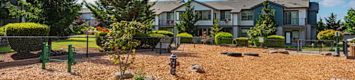 a courtyard with benches and trees in front of an apartment building