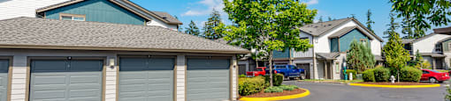 a neighborhood of garages with cars parked in front of them