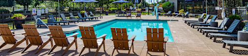 our resort style pool is filled with lounge chairs and umbrellas
