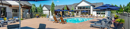 our apartments have a pool and patio with chairs and umbrellas