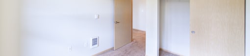 a bedroom with white walls and carpet