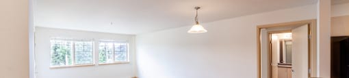 a spacious living room with white walls and carpet