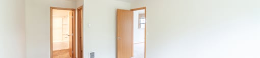 a bedroom with white walls and white carpet