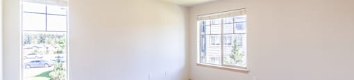 a bedroom with two windows and a carpeted floor