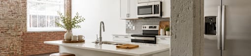 A kitchen with a white countertop and stools.