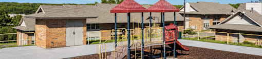 A playground with a red roofed structure and a slide.