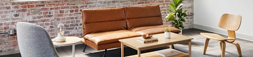 a living room with a couch and chairs and a brick wall at The Mill at Prattville, Prattville, 36067