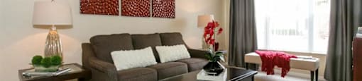 Living room area with a ceiling fan and big windows