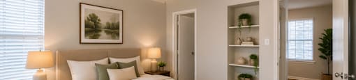 A bedroom with a bed, a ceiling fan, and a painting on the wall.