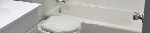 A white toilet sits next to a white sink in a small bathroom.