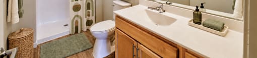 A bathroom with a toilet, sink, and shower.