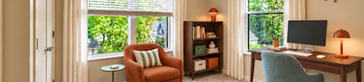 A room with a chair, a desk, and a window with curtains.
