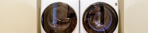 Two front load washing machines in a laundry room.