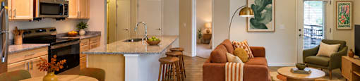 A modern kitchen and living room with a dining table and chairs.