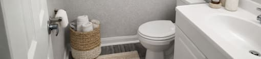 A bathroom with a toilet, sink, and a mirror.