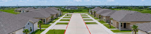 A long row of houses with a red line down the middle of the driveway.
